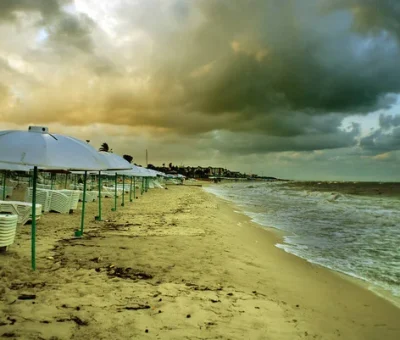 depositphotos_350820472-stock-photo-beach-coast-umbrellas-clouds